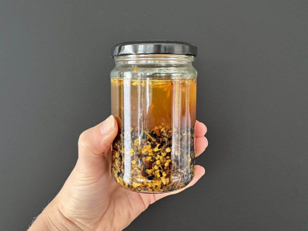 Deze Madame Jeanette Chili Crisp is een kruidige, pittige smaakmaker geïnspireerd op de variant van The Spice Girl. De combinatie van Madame Jeanette, mosterdzaad, nigella en komijn zorgt voor een fruitige hitte en een warme, aromatische ondertoon. Door hete olie over de specerijen te gieten ontstaat een geurige, knapperige chili-olie die alles van eieren tot zuurdesembrood naar een hoger niveau tilt. Zelfgemaakt is hij niet alleen verser en complexer, maar ook volledig aan te passen aan je eigen smaak.