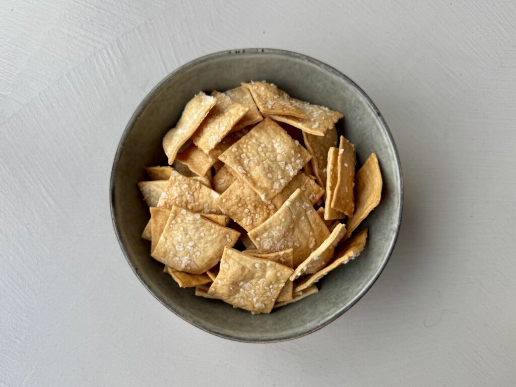 Deze olijfolie zuurdesem discard crackers zijn een eenvoudige manier om reststarter te benutten. Door zwakke bloem en minimaal kneden blijven ze bros en knapperig. Dun uitrollen en rustig bakken zijn bepalend voor het resultaat. Nadrogen in de oven zorgt voor een extra krokante afwerking.